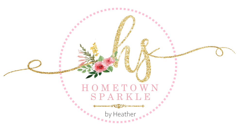 light pink dotted circle with gold lower case letters that are h & s with some pink and green flowers with by Heather below it in pink